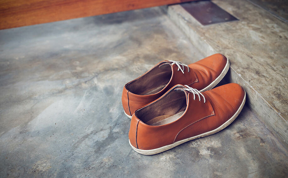 Pair if brown shoes sitting on a door step